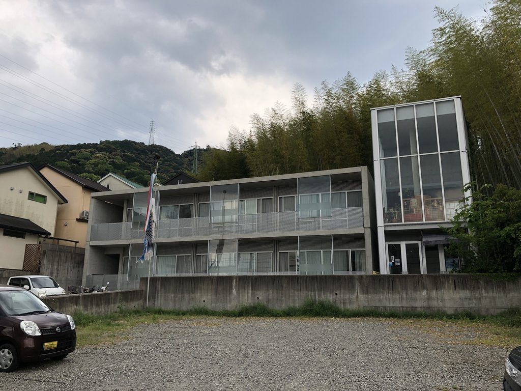 バルコニーとガラスのヴォリュームが並ぶ洛和グループホーム大山崎の正面外観 / Front elevation of Rakuwa Group Home Oyamazaki with balconies and a glazed volume
