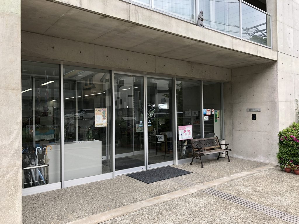 打放しコンクリートの庇とガラスで構成された洛和ヴィラ大山崎の入口 / Entrance to Rakuwa Villa Oyamazaki beneath an exposed-concrete overhang