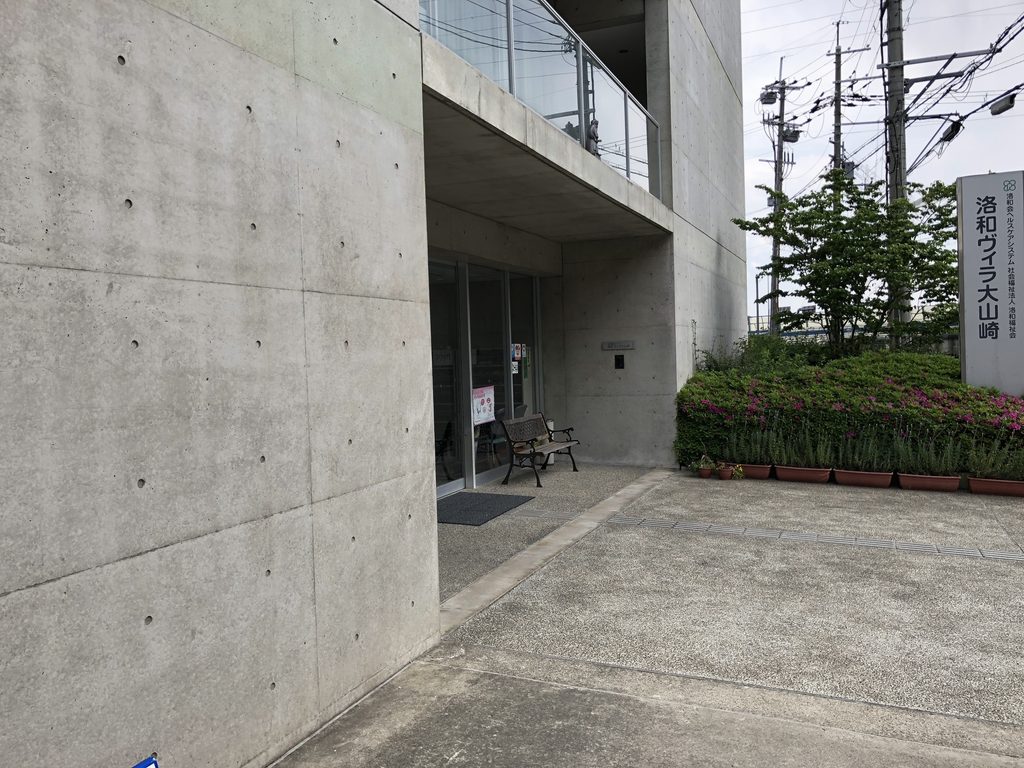 道路側から見上げる洛和ヴィラ大山崎のコンクリート外壁と開口 / Concrete wall and openings of Rakuwa Villa Oyamazaki viewed from the street