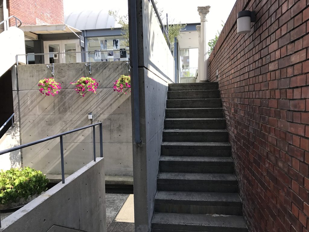レンガ壁の間を上るRIN'S GALLERYの外部階段 / Exterior stair rising between brick walls at Rin's Gallery