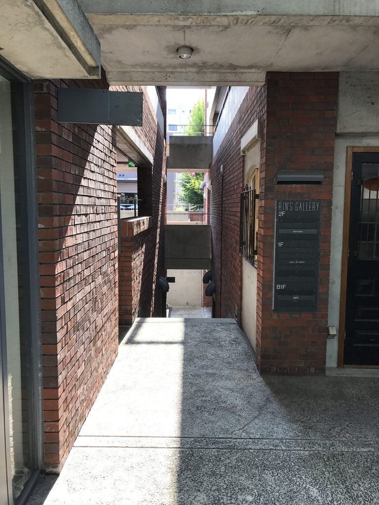 RIN'S GALLERY内部に現れる曲面コンクリート壁 / Curved exposed-concrete wall inside Rin's Gallery