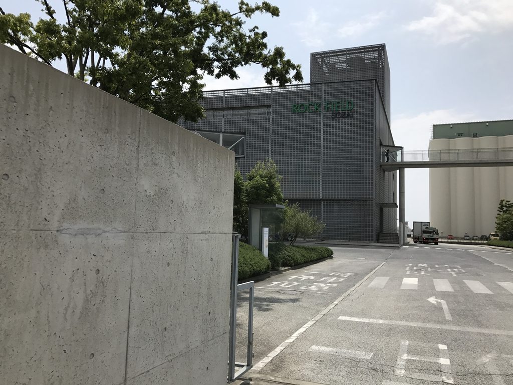 ロック・フィールド神戸ファクトリー入口から見る工場棟と植栽 / Factory buildings and planting seen from the entrance to ROCK FIELD Kobe Factory