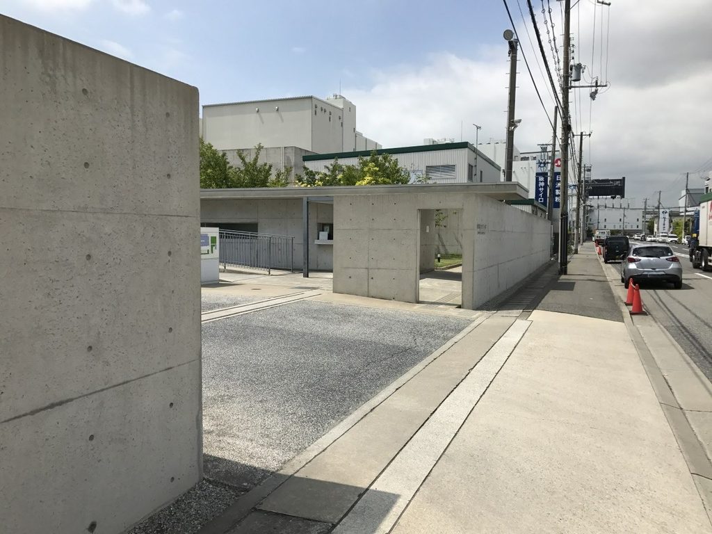 打放しコンクリート壁と樹木が続くロック・フィールド神戸ファクトリー外周 / Exposed-concrete wall and trees along the perimeter of ROCK FIELD Kobe Factory