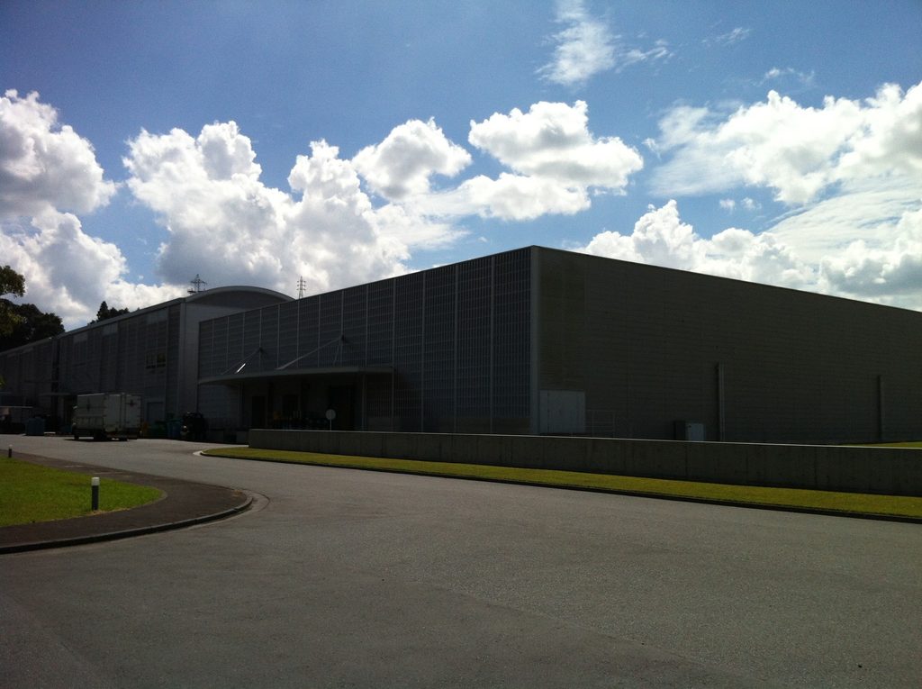 芝生の向こうに低く伸びる静岡ファクトリーの生産棟 / Low industrial building extending beyond the lawn at the Shizuoka Factory