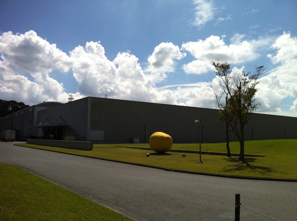 道路と芝生の間に配置されたロック・フィールド静岡ファクトリーの建物 / Factory building positioned between the internal road and lawn