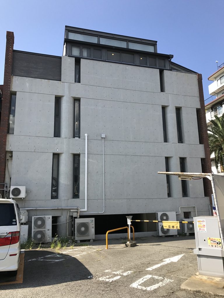 ローズガーデン裏側に現れる打放しコンクリート壁と縦長の開口 / Exposed-concrete rear wall of Rose Garden with narrow vertical openings