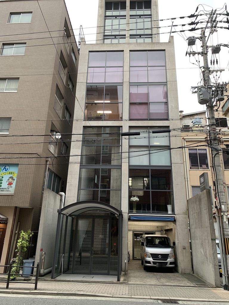 細長いコンクリートフレームとガラス面が立ち上がるSEASビル正面 / Front elevation of SEAS Building with slender concrete frames and tall glazed surfaces