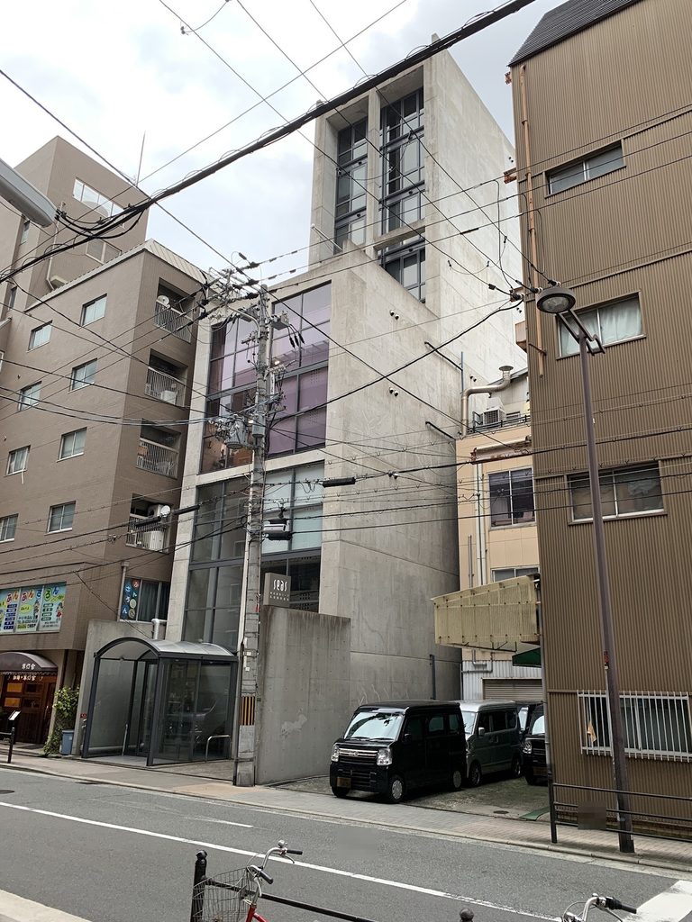電線と周囲の建物越しに見るSEASビルの全景 / SEAS Building seen among overhead wires and neighbouring buildings