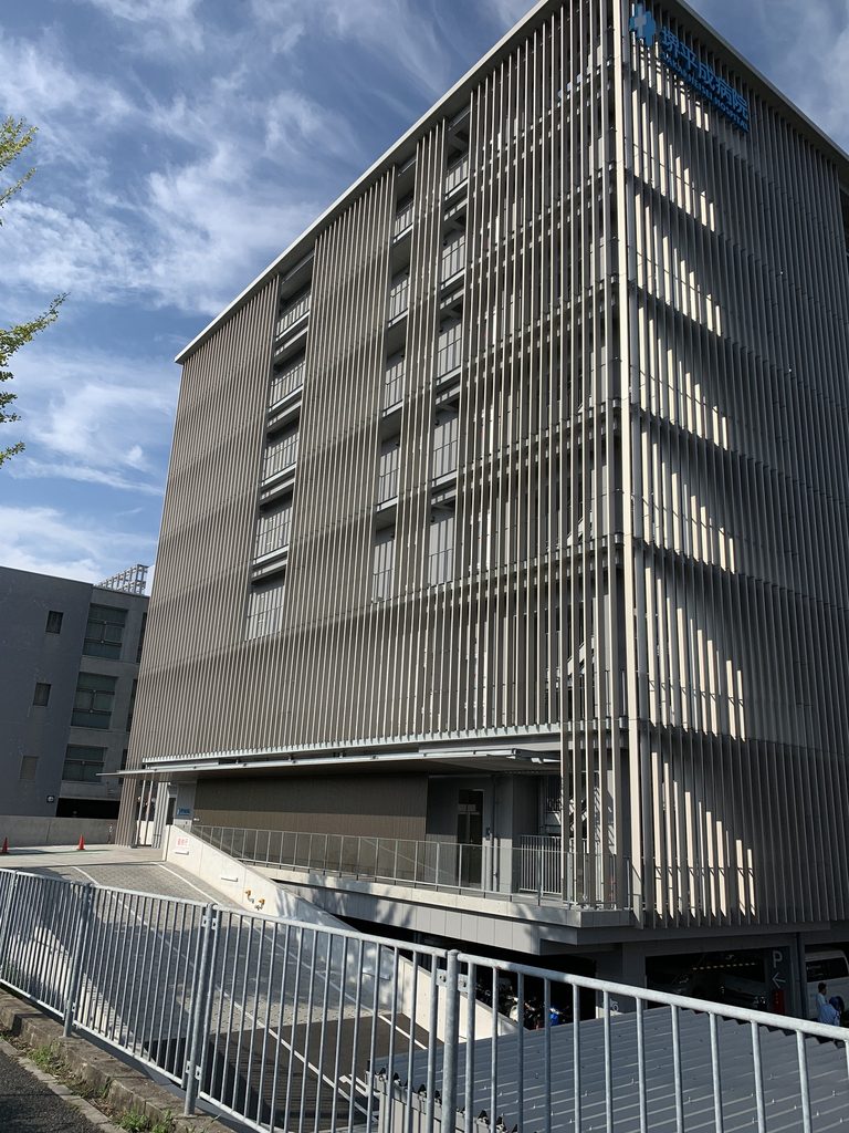 縦ルーバーの奥に窓と水平ラインが見える堺平成病院 / Windows and horizontal floor lines visible behind the vertical louvers of Sakai Heisei Hospital
