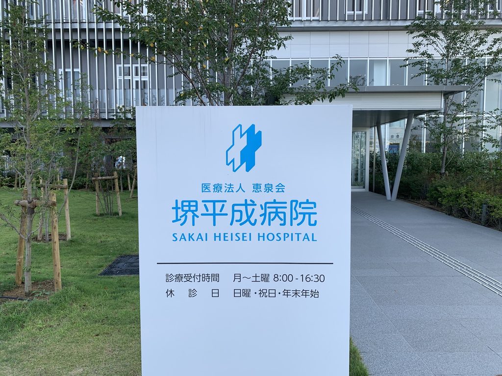 堺平成病院の案内サインと縦ルーバーの外観 / Sakai Heisei Hospital sign in front of the vertical-louvered exterior