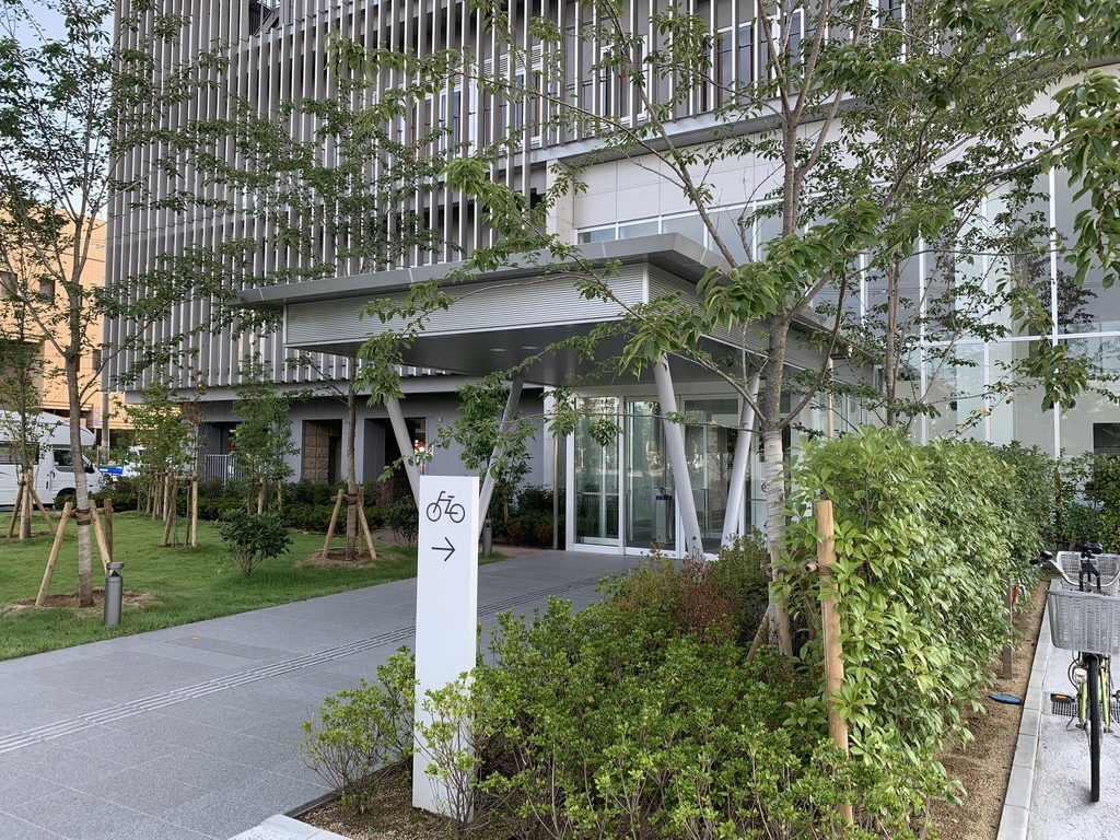 植栽越しに見る堺平成病院の地上階と縦ルーバー / Ground level and vertical louvers of Sakai Heisei Hospital seen beyond planting