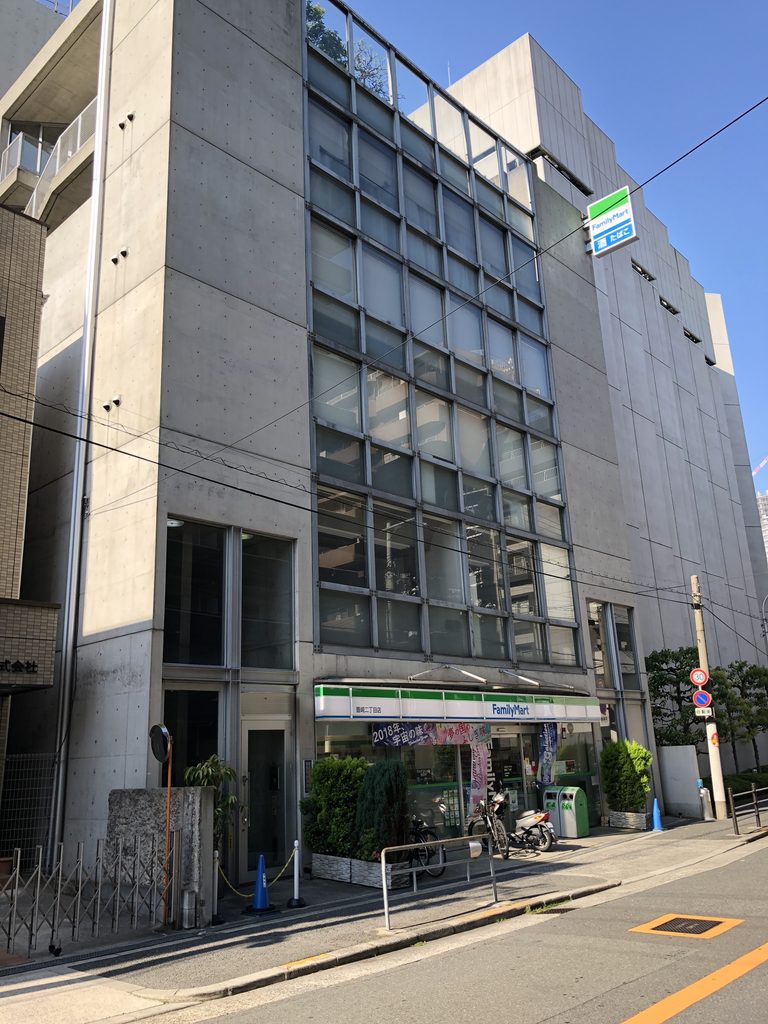 斜めから見たガラス格子と開口の少ない側面の壁 / Glass grid and largely closed concrete side wall seen from an angle