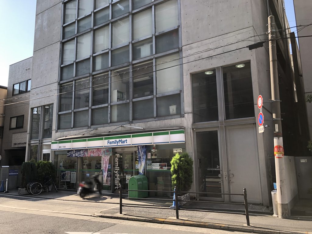 店舗脇に設けられた上階へ向かうガラス張りの入口 / Glazed entrance to the upper floors beside the ground-floor store