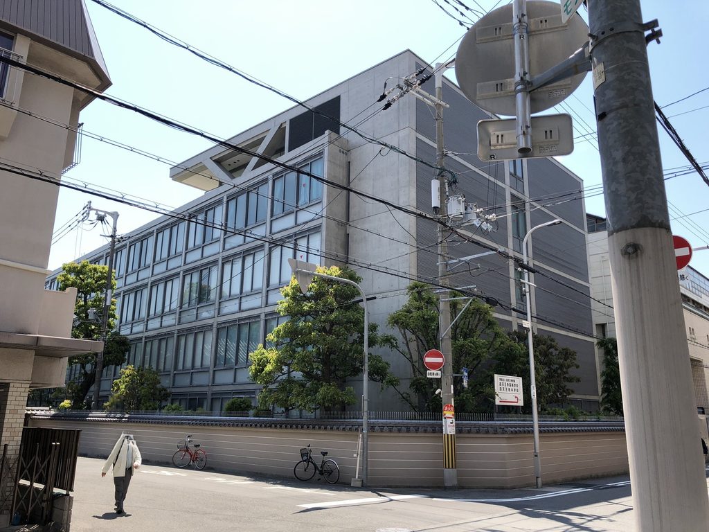交差点から見上げた四天王寺高等学校の長い校舎とコンクリート壁 / Long school wing and concrete end wall of Shitennoji High School viewed from the street corner