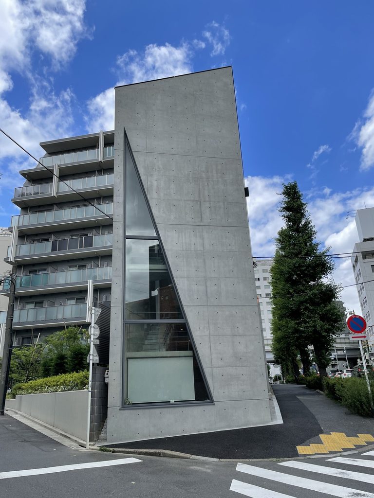 鋭角の敷地先端に立つシマ・クリエイティブハウスと上方へ細くなる三角形の窓
Sima Creative House at the pointed end of its site with a triangular window tapering upward