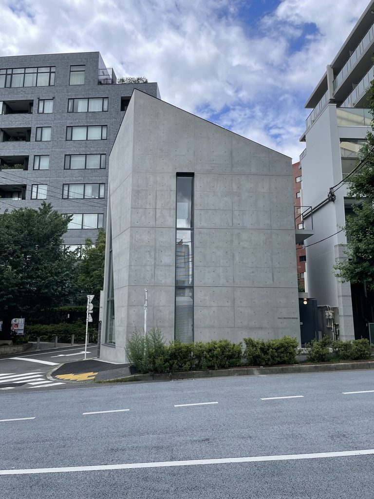 道路向かいから見たシマ・クリエイティブハウスの傾斜する屋根線と縦長のガラススリット
Sloping roofline and narrow vertical glass slit of Sima Creative House viewed from across the street