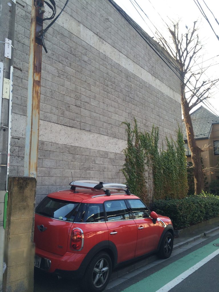 蔦に覆われたブロック壁と赤い車が並ぶ旧SUPER POTATO本社側面 / Ivy-covered block wall along the side of the former SUPER POTATO headquarters