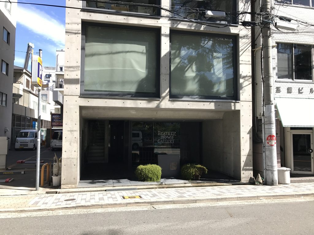TSビル低層部の大きな窓と奥まった街路側入口 / Large lower-level windows and recessed street entrance of TS Building