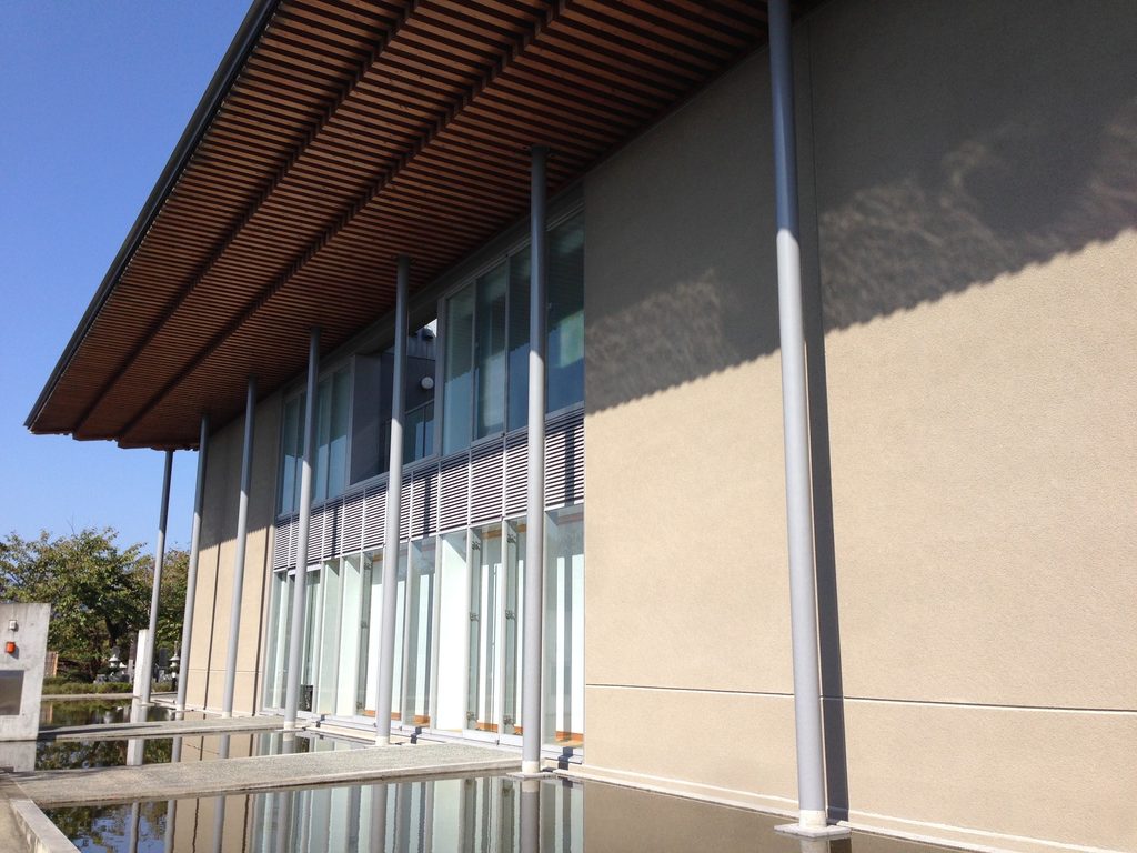 水盤に沿って続く太岳院本堂のガラス面と細い柱 / Glazing and slender columns extending beside the reflecting pool at Taigakuin Temple