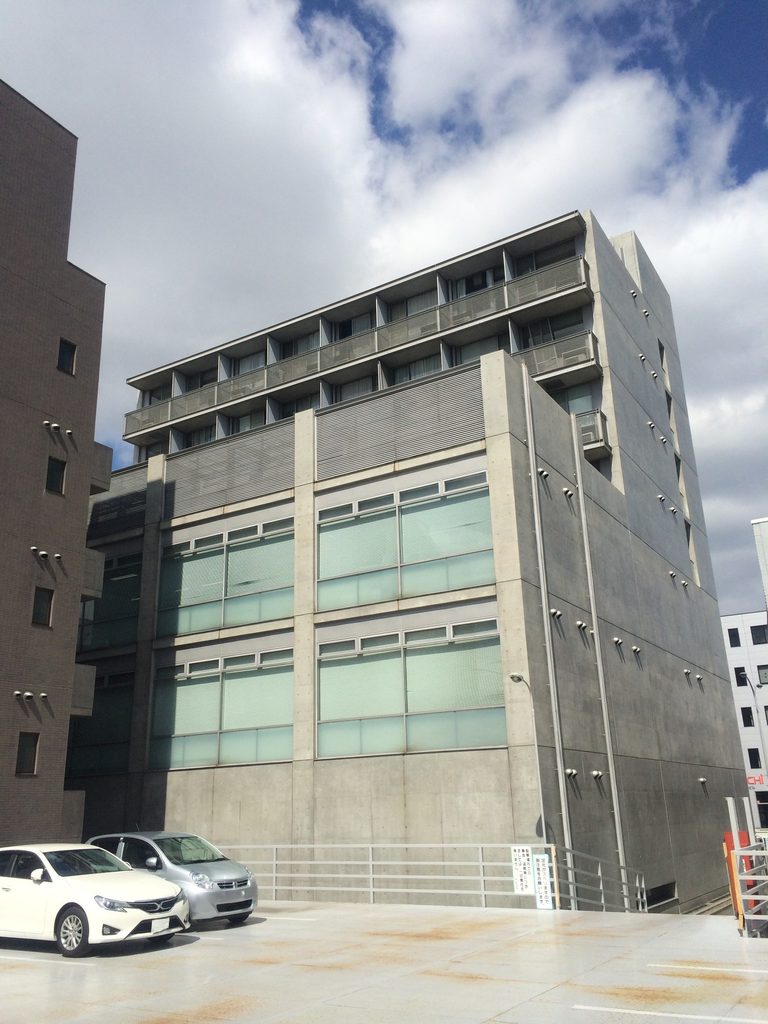ガラス面とコンクリートの柱梁が見えるTHE QOLの裏側 / Rear elevation of THE QOL with glazing and concrete frame