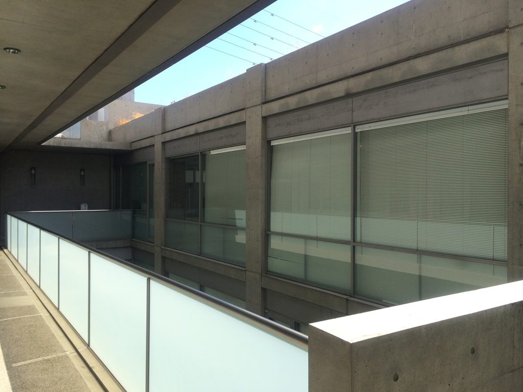 吹抜けに沿って続くTHE QOLのガラス張りの回廊 / Glazed walkway extending along the open void at THE QOL
