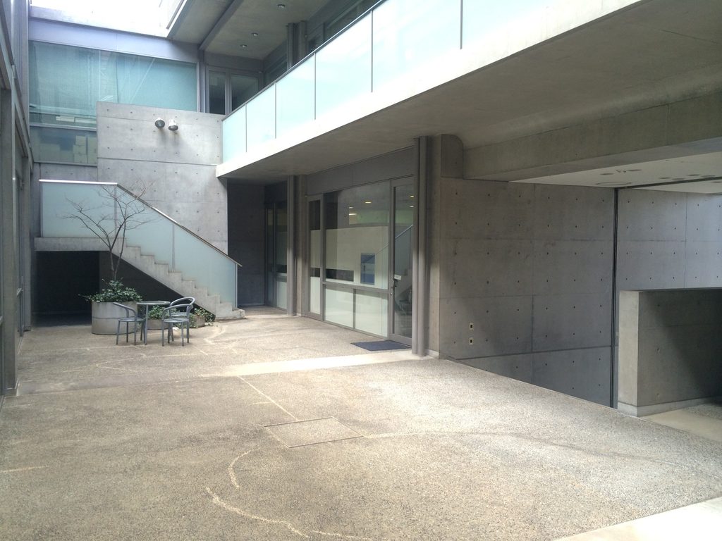 階段と上階回廊が重なるTHE QOLの外部空間 / Exterior space at THE QOL with stairs and an upper-level walkway