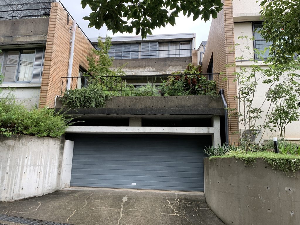 道路側のガレージとその上に重なるテラスと住戸 / Street-level garage with terrace and dwelling stacked above