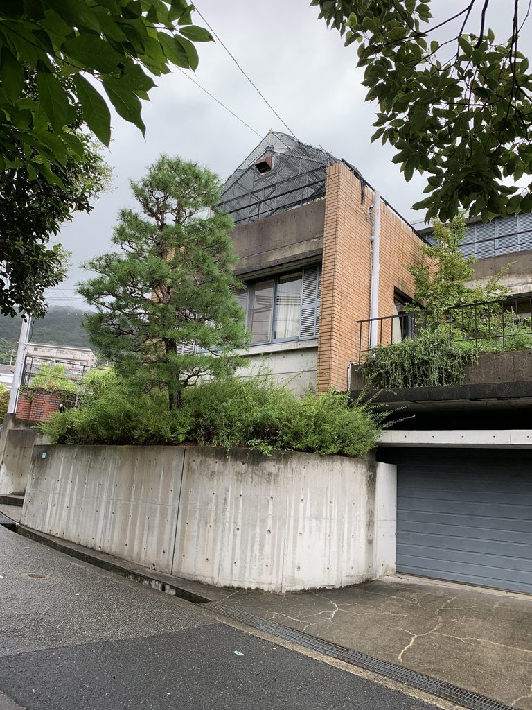 芦屋の坂道に沿ってタイル壁とコンクリート擁壁が立つビューコート朝日ケ丘 / Viewcourt Asahigaoka with tiled walls and concrete retaining walls along a sloping street in Ashiya