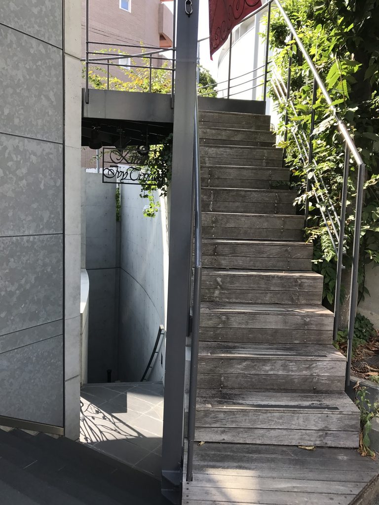 WALL STEP正面脇から上階へ延びる細い外部階段 / Narrow exterior stair rising beside the facade of WALL STEP