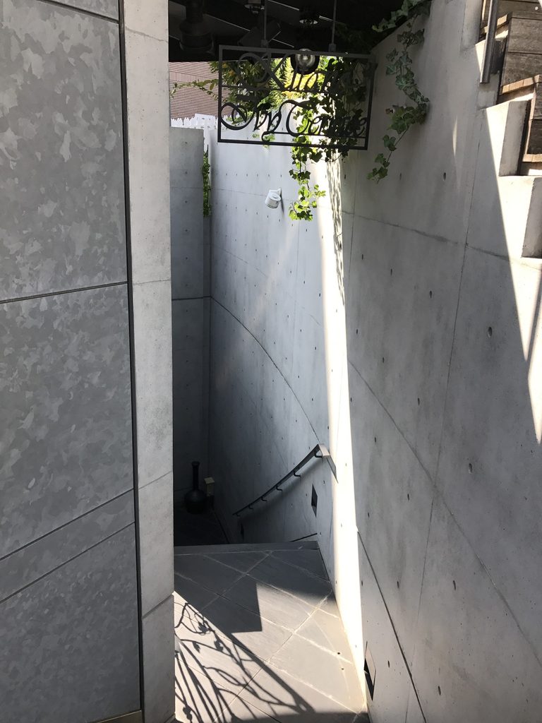 コンクリート壁の間を地下へ降りるWALL STEPの階段 / Stair descending between concrete walls at WALL STEP